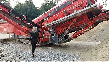 Granny is walking around in a gravel pit wearing sheer leggings